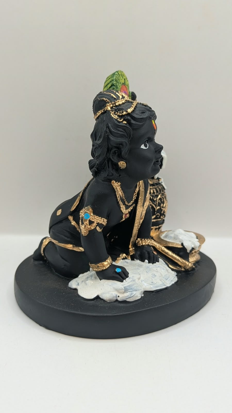 Black and gold baby Krishna statue with butter pot, other side view