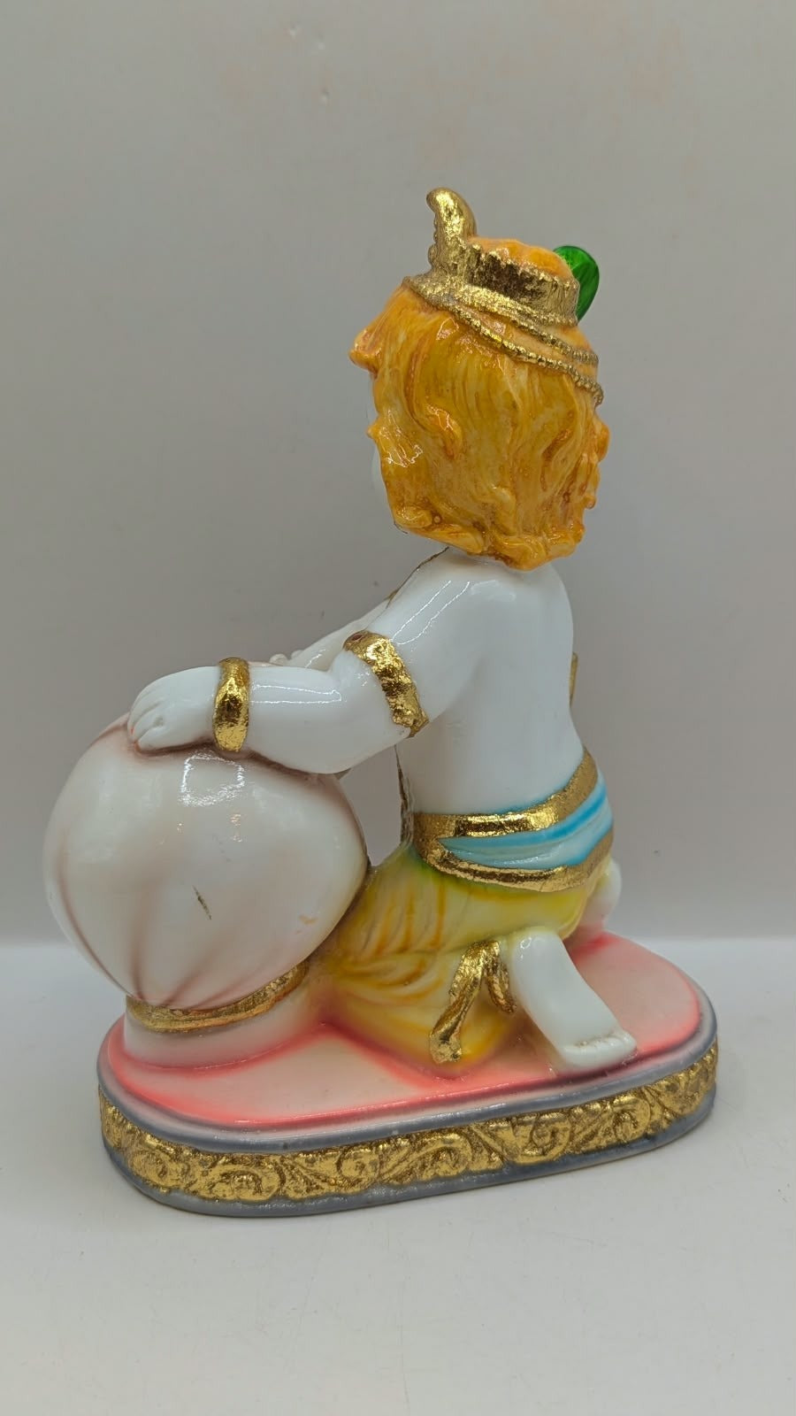 Baby Krishna statue with white pot, back view