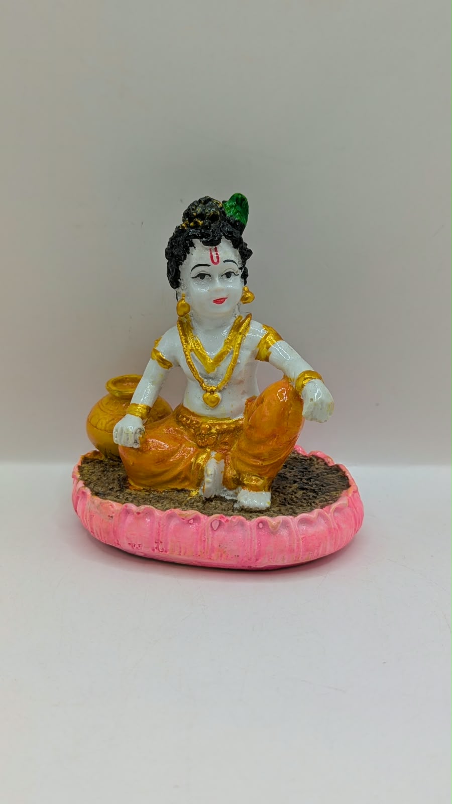 Baby Krishna statue on pink lotus, front view