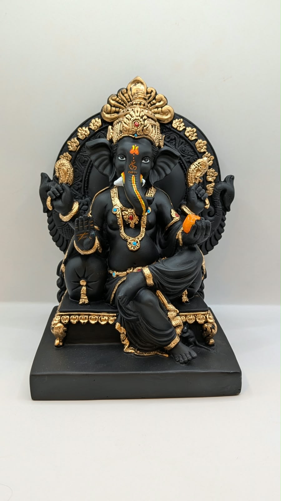 Black and gold Ganesh on throne, front view