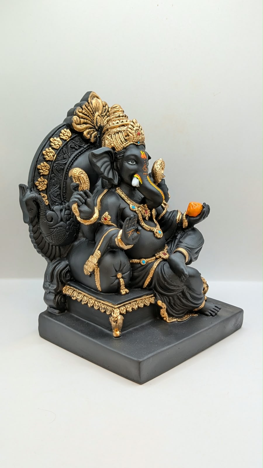 Black and gold Ganesh on throne, side view