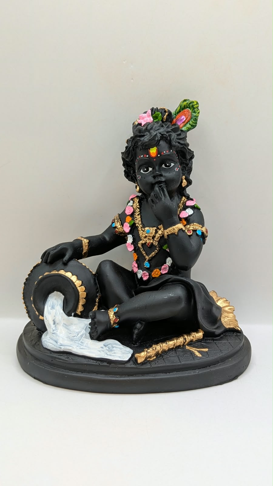 Black baby Krishna with butter pot, front view